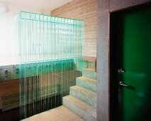 Green lacquered living room door in the concrete stairway and a balustrade made of glass louvers