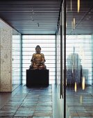 Buddhastatue im minimalistischen Vorraum auf Schieferplatten