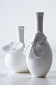 weiße Vasen mit Blütenapplikation