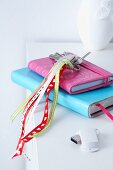 A bunch of keys hung with ribbons on top of colourful notebooks