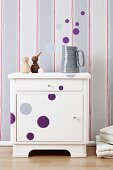 Wall stickers stuck on a white cupboard and ion stripy wallpaper