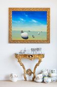 Picture in a gold frame over a rococo wall table and porcelain crockery