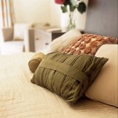 Various coloured cushions on a bed