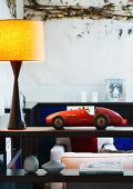 Retro toy car and lamp on wooden shelf