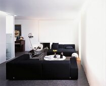 White modern living room with black seating on a grey floor
