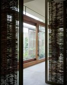 View between bamboo matting partitions onto extensive glass sliding doors