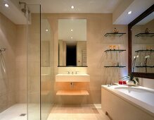 Bathroom completely tiled in stone with floor-level shower and large mirror