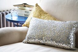 Sequinned cushions on light armchair