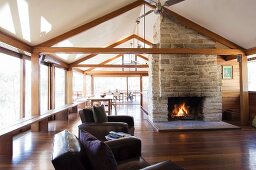 Spacious living room with fireplace and benches along the long glass wall