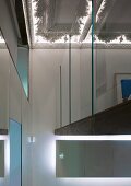 Gallery with glass wall beneath stucco ceiling with indirect lighting in foyer of a villa