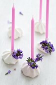 Candles in meringue candleholders decorated with lavender flowers