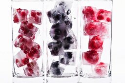 Three glasses with various berry ice cubes