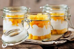 Frische Mangostückchen mit Joghurt in Einweckgläsern