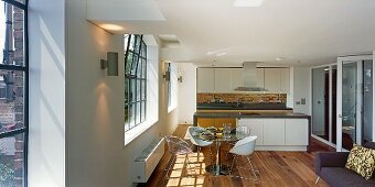 Loftartiger Wohnraum mit modernem Essbereich vor Küchenblock
