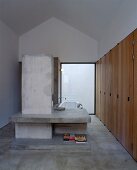 Designer Bad mit betoniertem Raumteiler mit Ablage vor Badewanne