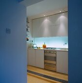 Blick durch offenen Durchgang auf funktionale Küche