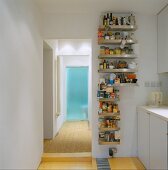 Stainless steel kitchen shelving with groceries next to open doorway