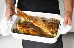 Red snapper with vegetables in a roasting dish