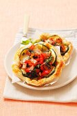 Puff pastry tartlets topped with courgettes, spinach, pepper and mozzarella