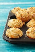 Apple muffins topped with nut crumble in a muffin tin