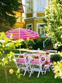 A summer garden table with a sunshade in front of a house