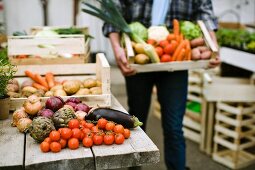 Mann hält Steige mit frischem Gemüse