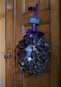 Festive wreath of pine cones on wooden door