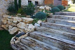 Treppe neben einem Hochbeet mit Natursteineinfassung