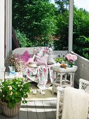 White wicker furniture and geranium on balcony