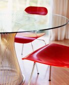 Rot gebeizte Holzstühle am Glastisch mit Metallfuss