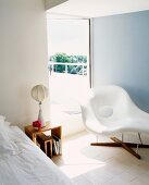 White chaise longue in front of terrace door in bedroom
