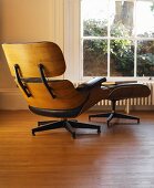 Armchair and footstool with leather upholstery in front of window