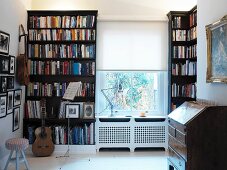 Ein Arbeitszimmer mit Bücherregalen und einem Sekretär