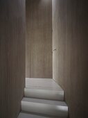 Oberste Treppenstufe in puristischem Flur mit flächenbündig in Holzverkleidung integrierten Türen