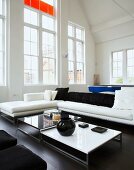 Living room with sofa, coffee table & ceiling-height windows