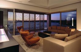 Living room with sofa, armchairs, coffee table & sliding louver doors leading to terrace