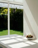 Dining table with fruit bowl next to terrace window