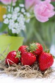 Tischdeko mit Erdbeeren auf Stroh