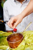 Strawberry Dipping into Chocolate Fondue