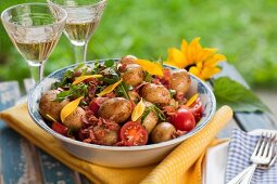 Potato salad with tomatoes, bacon and rocket