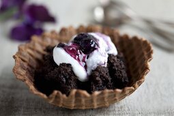 Waffle bowls filled with crumbled brownies, cream and blueberries