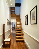 Art Nouveau-period chair and open wooden staircase in narrow hall