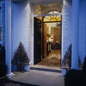 Entrance to English house with Christmas decorations and open door with view into interior room