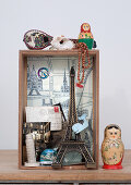 Kleine Vitrine mit Souvenirobjekten und russischer Puppe (Matrjoschka) auf Tisch