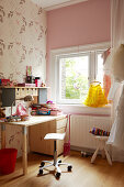 A desk and a wheeled chair in a child's bedroom