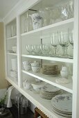 Country-style glasses and crockery in white shelving unit