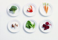 Various types of vegetables on white plates
