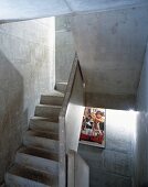 Concrete stairwell with illuminated film poster on wall