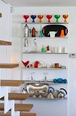 Colourful, postmodern kitchen utensils on stainless steel kitchen shelves