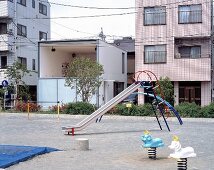 Children’s playground in front of modern houses and contemporary house with large window